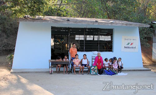 La maestra, los estudiantes y do�a Cari con donativos frente a la escuela de Mata de Sand�a